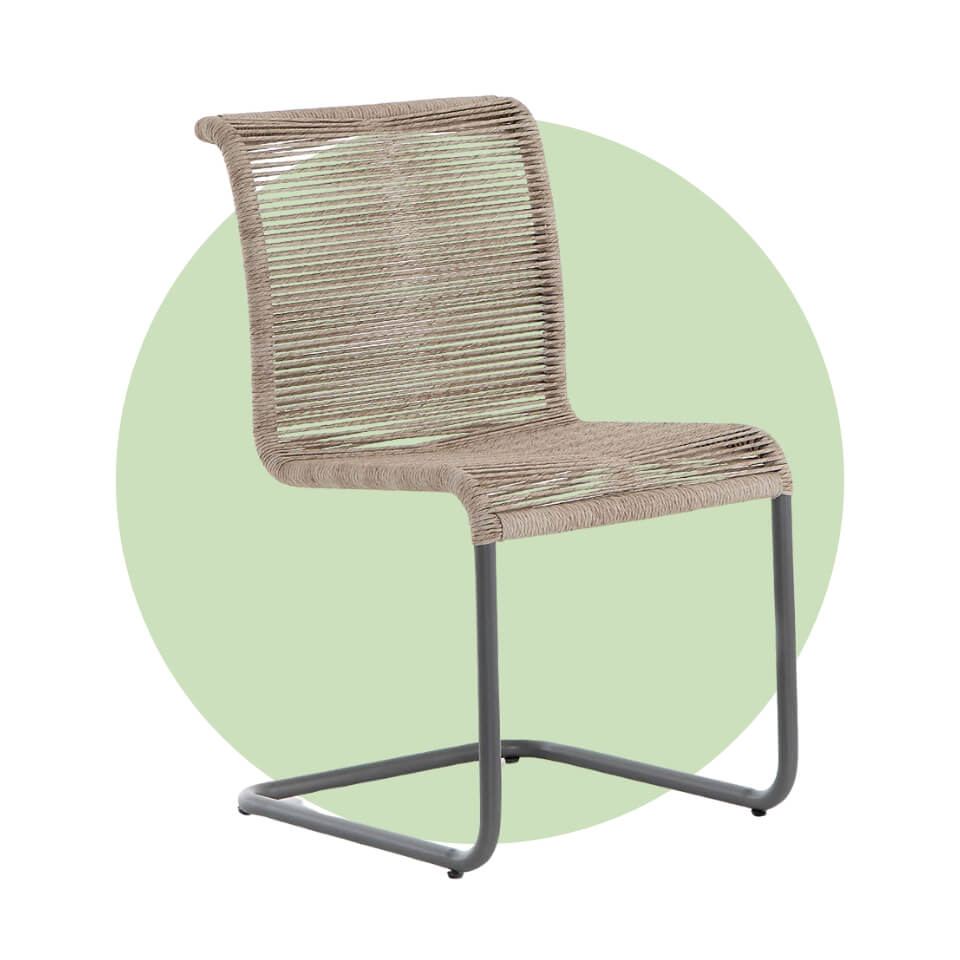 A chair with a wicker seat and iron base over a light green circle