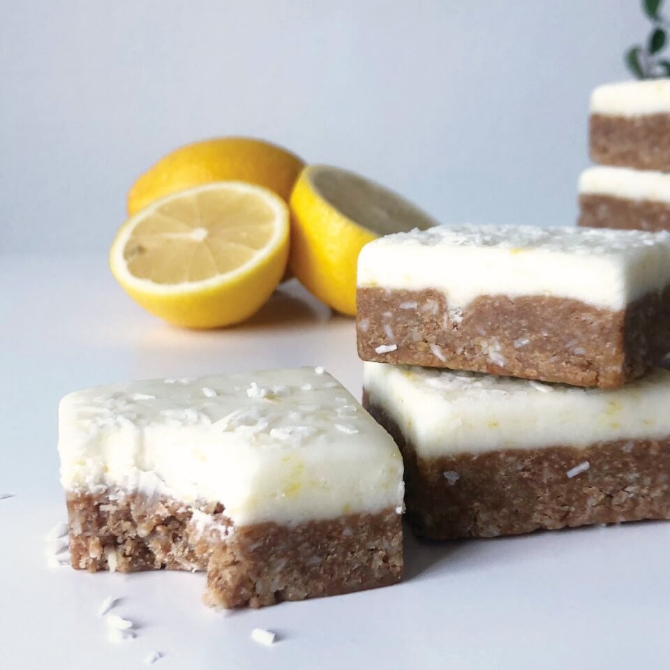 Lemon dessert squares with halved lemons visible in the background