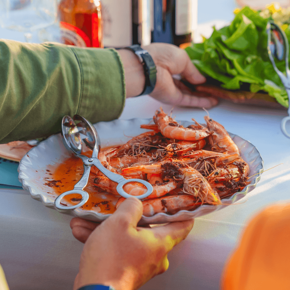 person serving dish of prawns