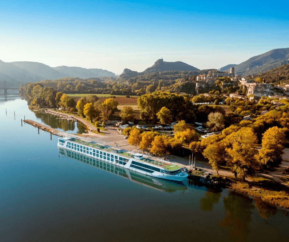 river boat in front of historic architecture and rolling hills