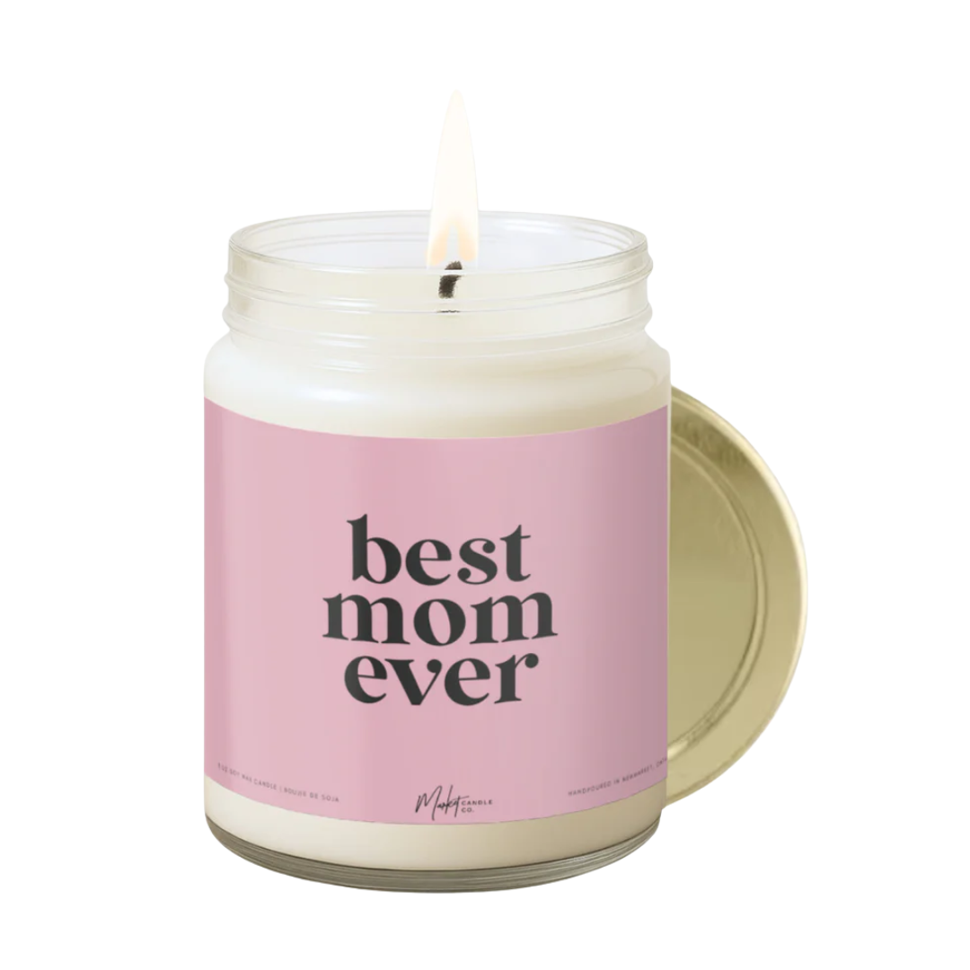 Candle with gold lid and pink label. 