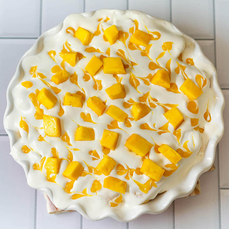 Tasha's Artisan Food's recipe for mango float is topped with swirls of mango purée and mango cubes.