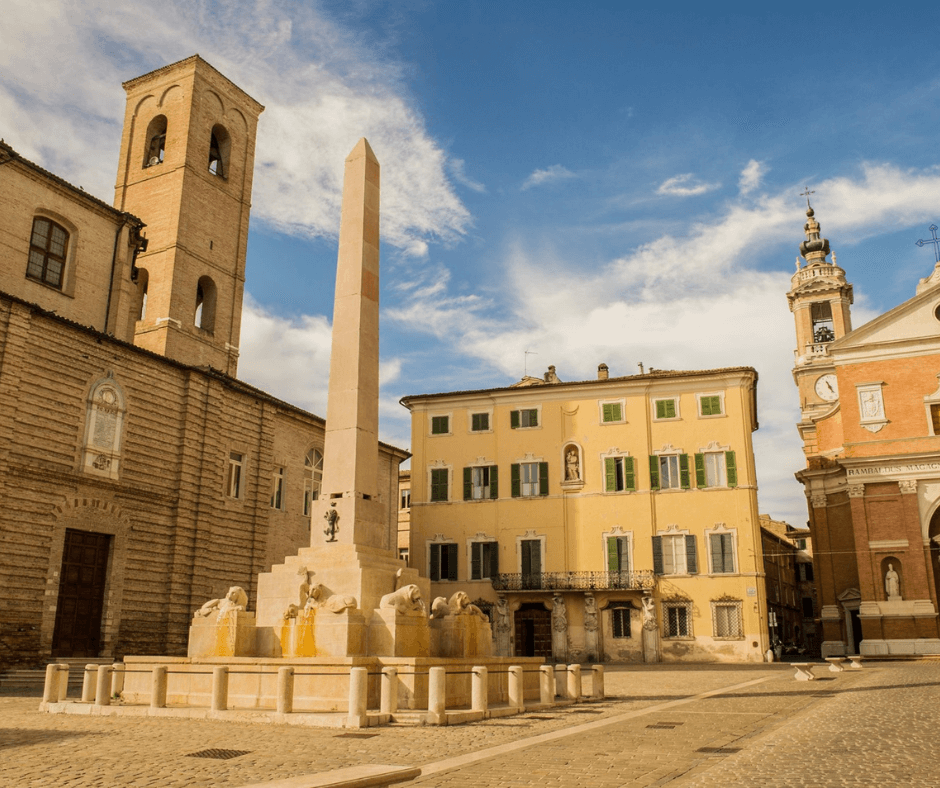 historic town buildings with obelisk fountain