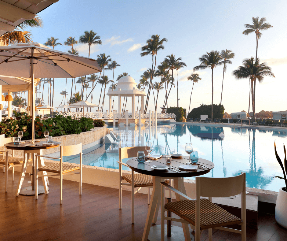 Outdoor dining tables beside pool at Paradisus Palma Real, Dominican Republic