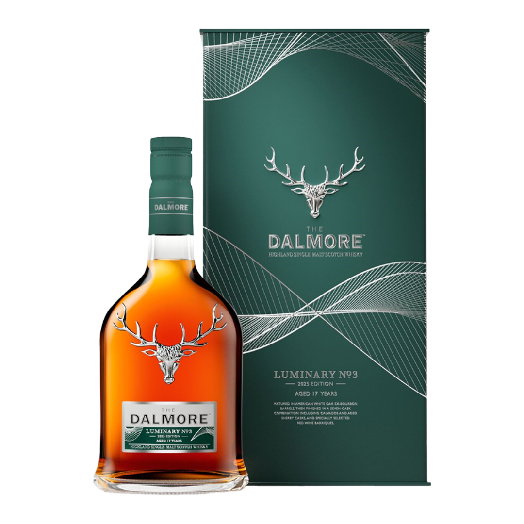 An amber bottle of aged whisky next to a green display box.