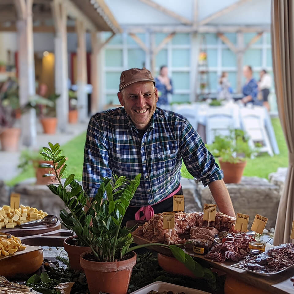 Canadian cheese master Afrim Pristine, poses with a table laden with food from his store the Cheese Boutique