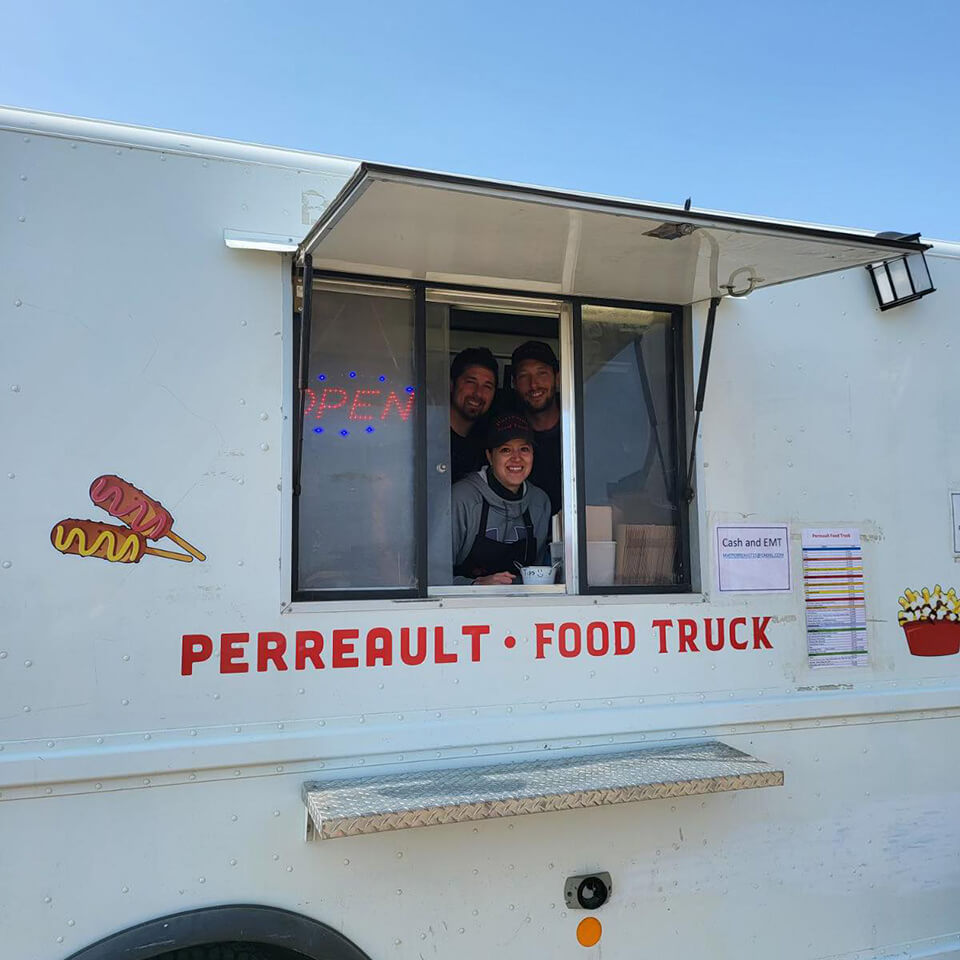 Three people in the window of a white food truck