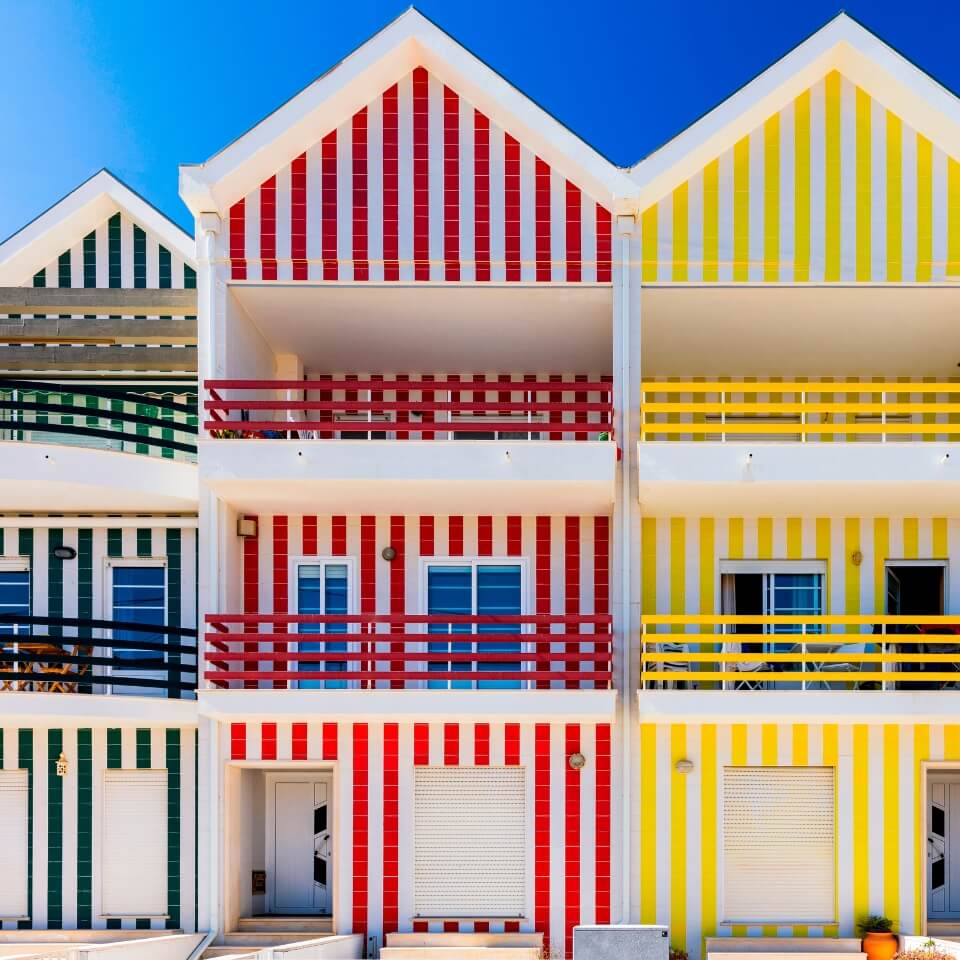Three houses striped in white with green, red and yellow