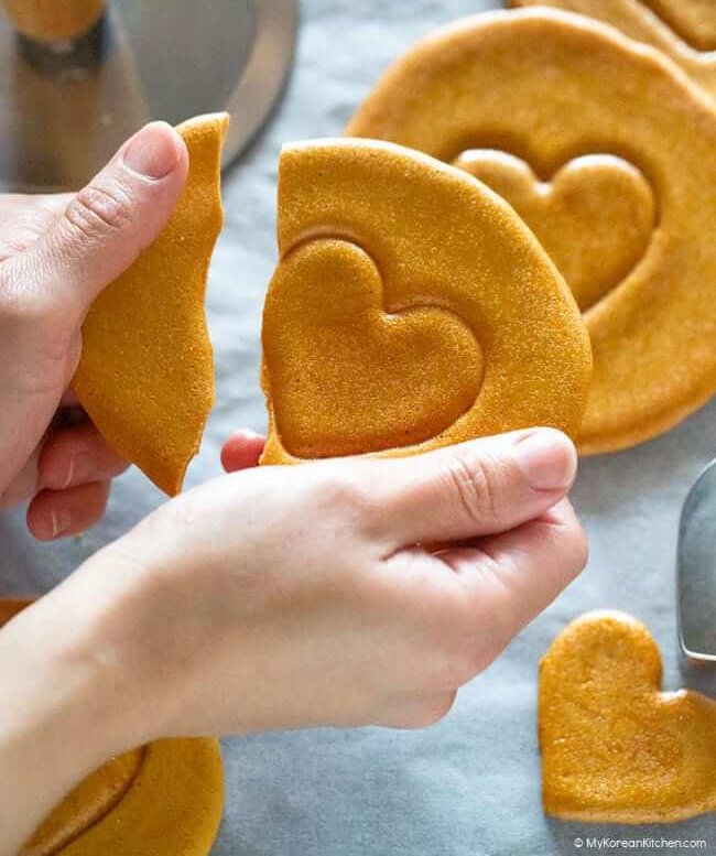 woman breaking dalgona candy