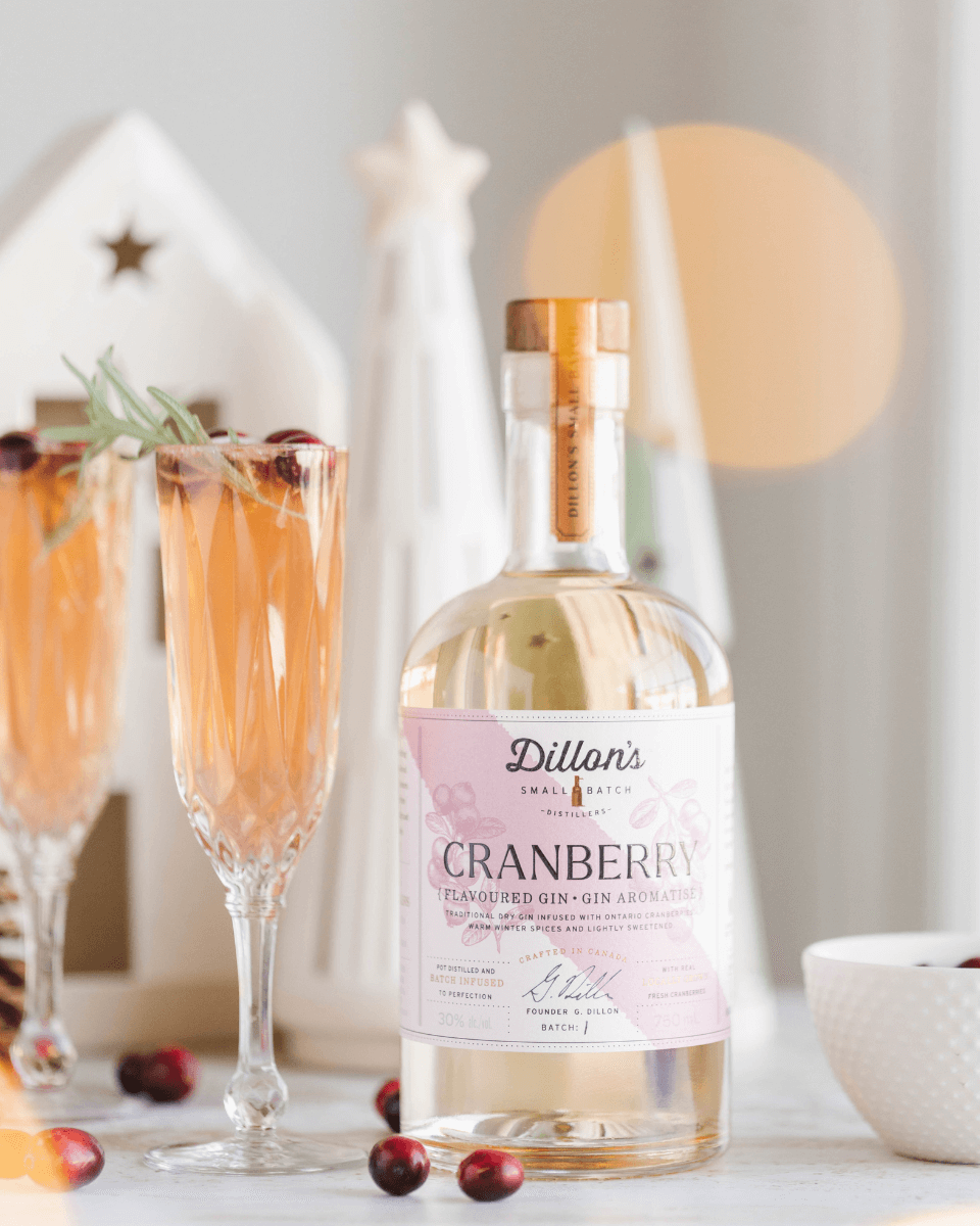 Bottle of gin next to pink cocktails