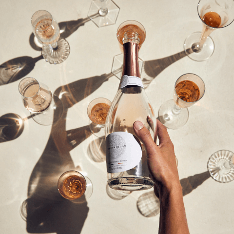 A bottle of the new French Bloom Non-Alcoholic wine being poured into glasses