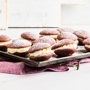 Red velvet whoopie pie sandwiches on cooling rack