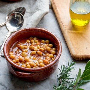 A brown ceramic bowl with chickpea soup