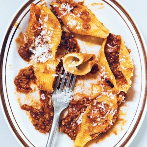 A white dish with lamb ragu and pasta shells