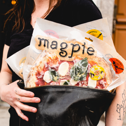 Woman holding frozen pizza from canadian company in her purse