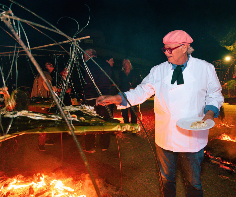 Chef Francis Mallmann at nighttime cooking over an open fire, Bodega Garzòn Harvest Party, Uruguay