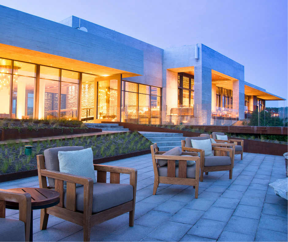 The back elevation of the Bodega Garzón Winery, Uruguay at sunset. A beautiful terrace with teak chairs