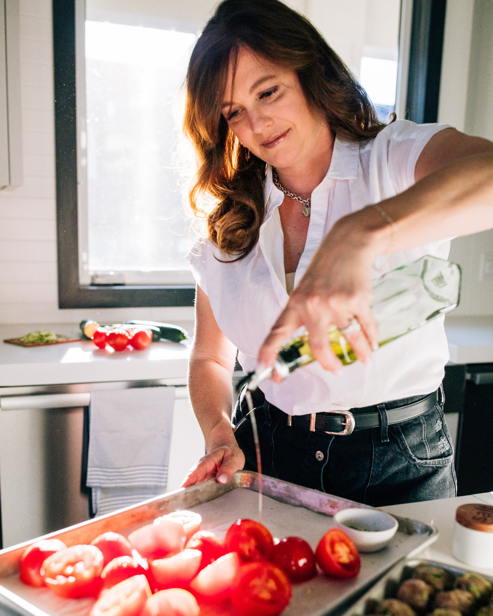 Canadian Blogger Holly Nillson is Drizzling Olive Oil on Tomatoes in her kitchen