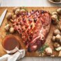 Maple glazed ham with caramelized crust served with baby potatoes on wooden board