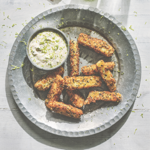 Crispy fried halloumi sticks with sesame seeds, served next to a chili yogurt dip with lime zest.