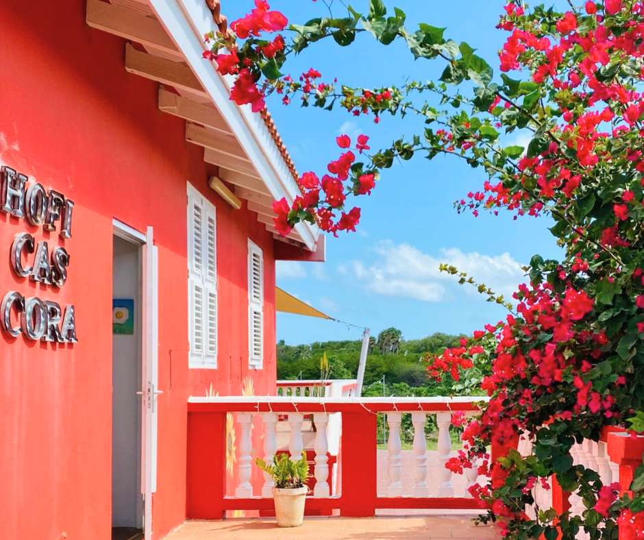 Exterior of Hofi Cas Cora, Curaçao with beautiful bougainvillea and red stucco
