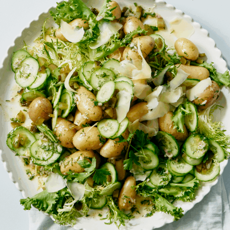 Bowl of potato cucumber salad with shaved Comté
