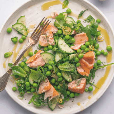 plate with green peas, herbs and chunks of smoked salmon