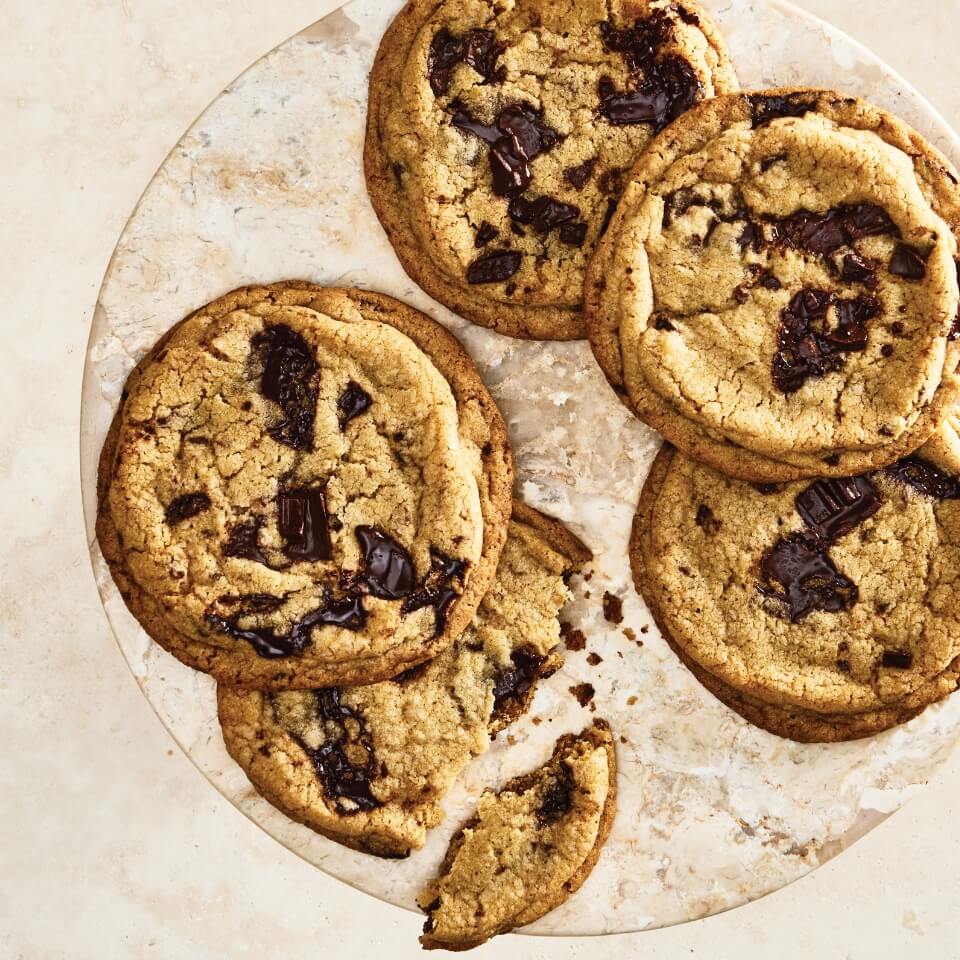 Five chocolate chip cookies on a plate.