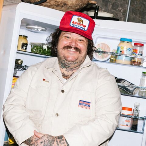 Matt Matheson stand in red baseball cap standing in front of an open fridge.
