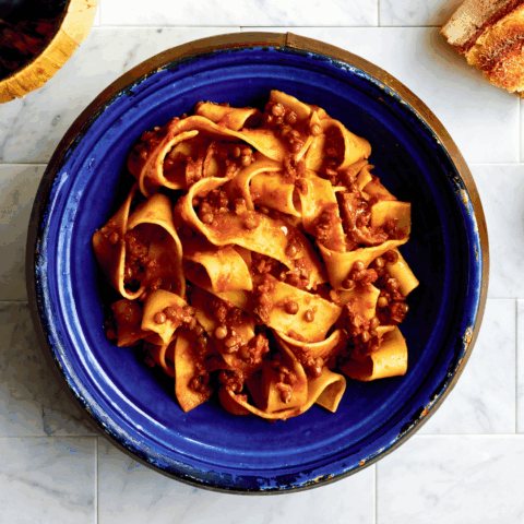 Blue bowl filled with bolognese with lentils and mushrooms.