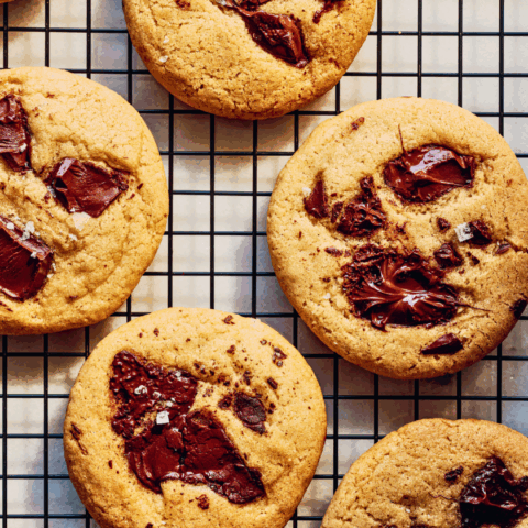 Chocolate chunk cookies on a black wire rack.