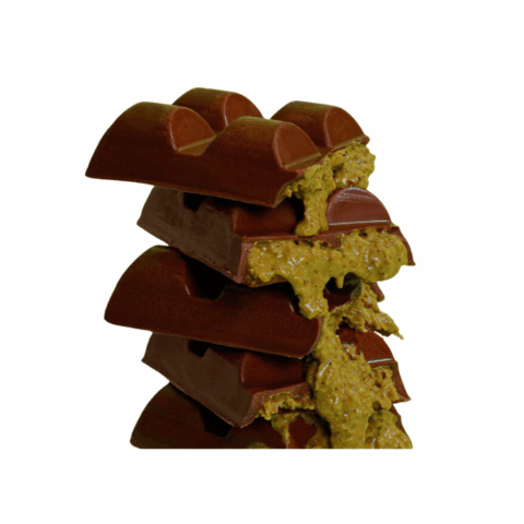 Chocolate bars broken in half and stacked to show a pistachio knafeh filling.