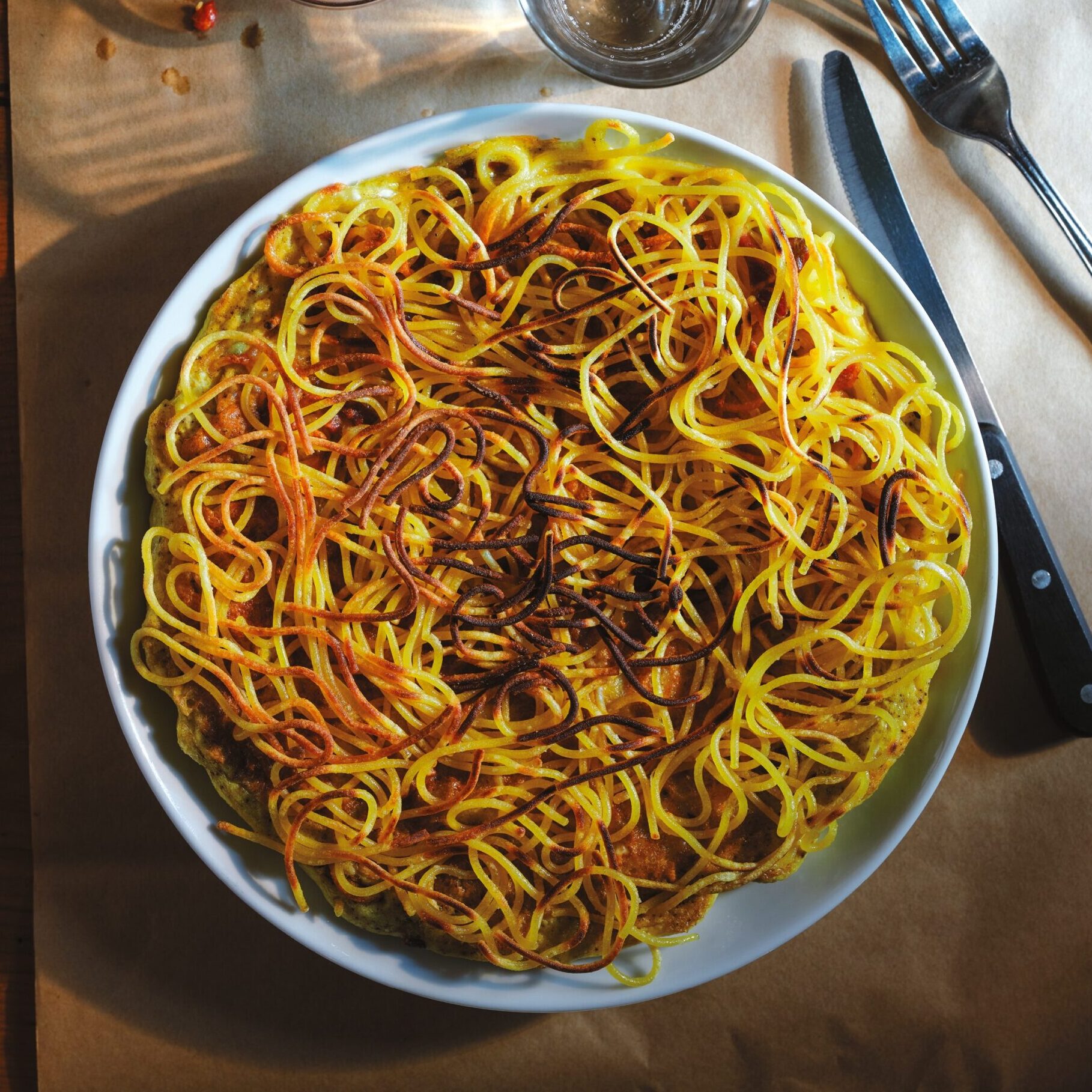 A plate with spaghetti frittata on it.