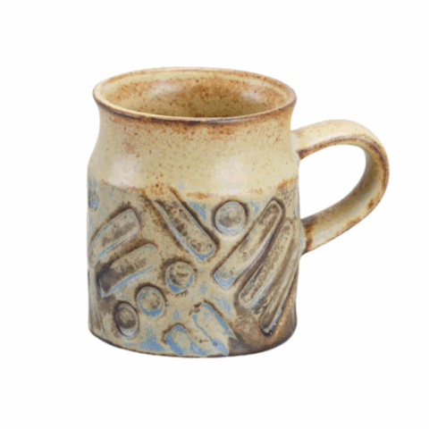 A tan-coloured clay espresso cup with geometric imprints.