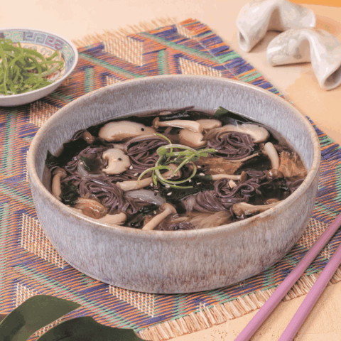 A bowl of miso soup with mushrooms.
