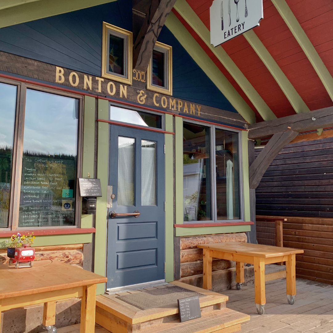 Exterior of a blue entry-way with red roof and green accents.