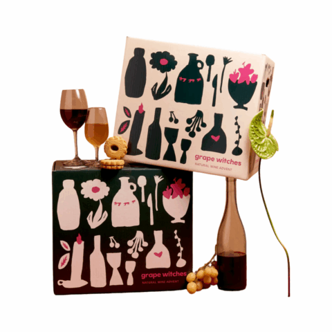 Two boxes with a bottle and two glasses of wine and grapes surrounding it.