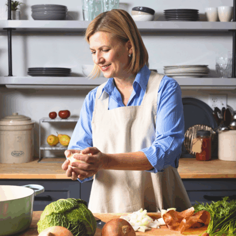 Anna Olson Portrait - she's in kitchen cutting vegetables