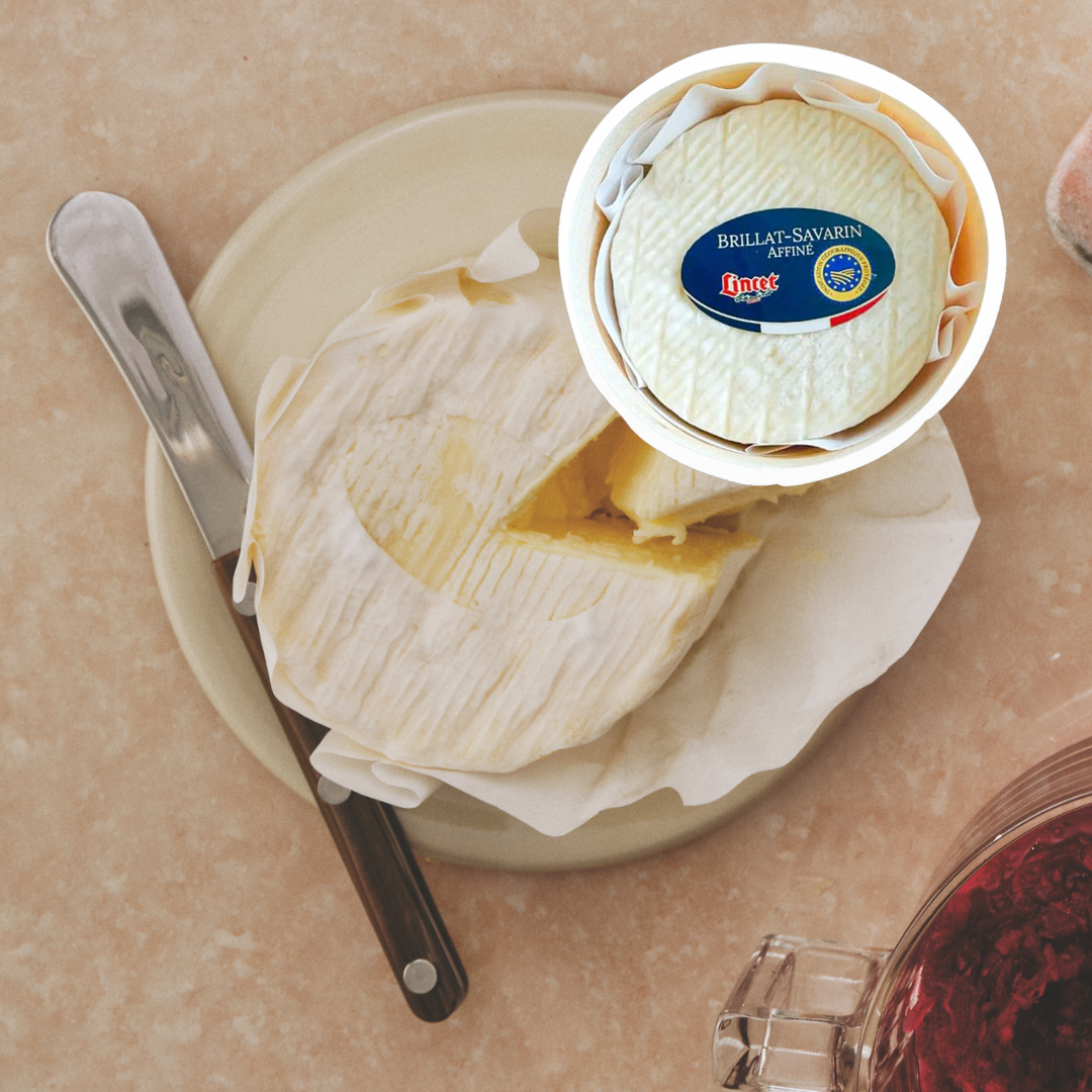 Image of brillat savarin cheese with piece cut out to show the creamy inside