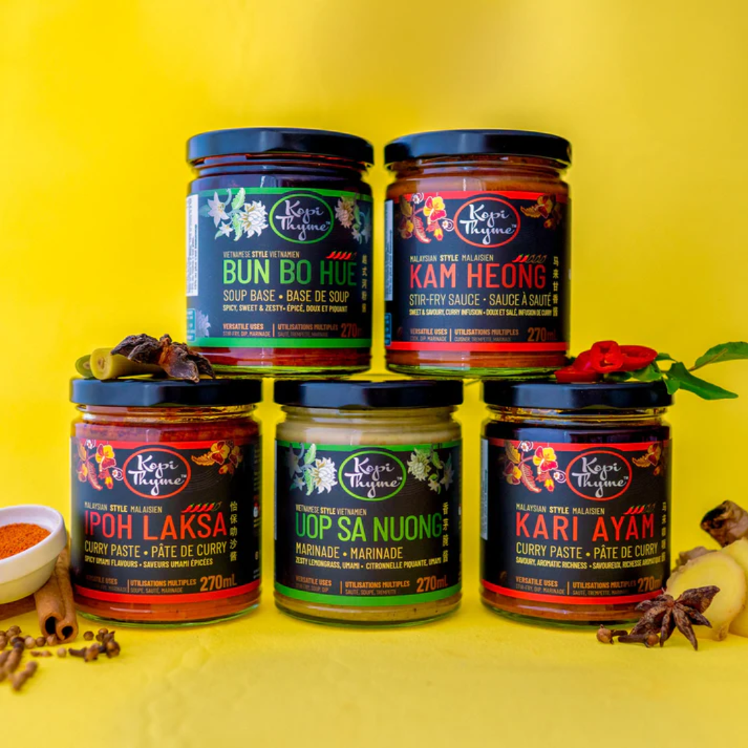 Five jars of marinades and sauces on a yellow background.