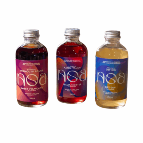 Three bottles of non-alcoholic cocktails with colourful labels and silver caps.