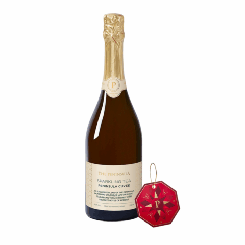 A dark red bottle of sparkling tea with a gold seal and tan label, next to a red octagonal paper tag.