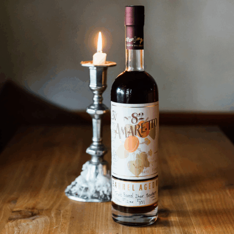 Sns of vancouver bottle of amaretto with a candle lit in the background