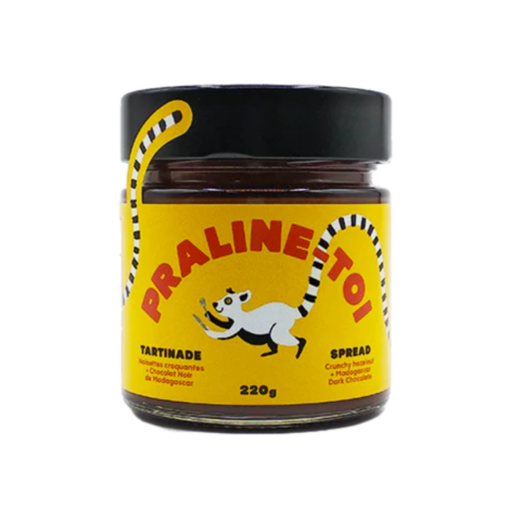 Jar of hazelnut dark chocolate spread with a black lid and a yellow label with an illustrated lemur logo.