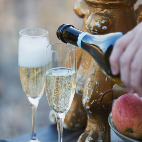 Close-up shot of a bottle of Prosecco being poured into a flute glass.