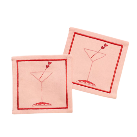 Pink cloth cocktail napkins with a red border and illustration of a martini glass.