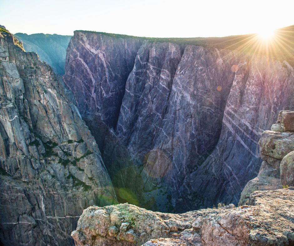 Steep canyon cliffs with sunlight over Black Canyon of the Gunnison National Park.