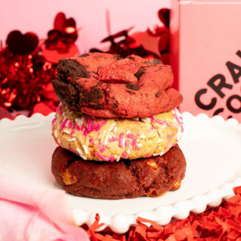 A stack of three red cookies on a white handkerchief.