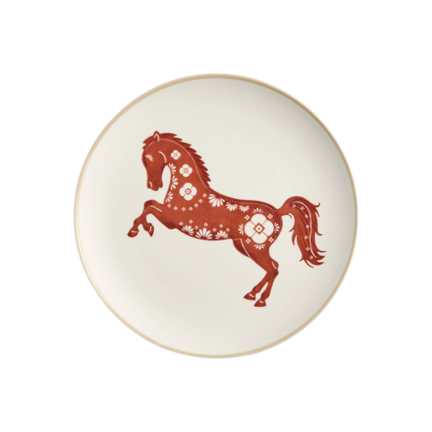 A white stoneware plate with a red decorative horse design on it.