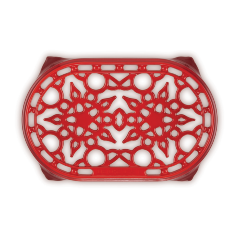 Top view of a red ceramic oval trivet.